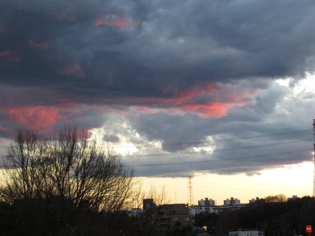 真っ黒い雲の中に夕日の雲が光ります。