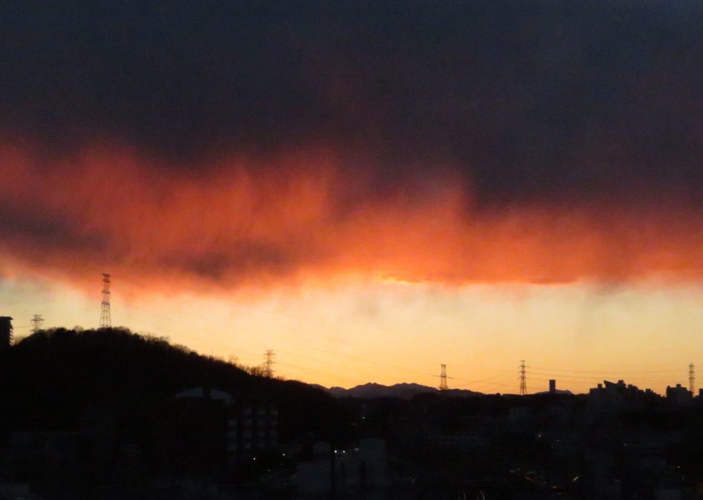 真っ黒な雲と真っ赤な雲の夕日です。